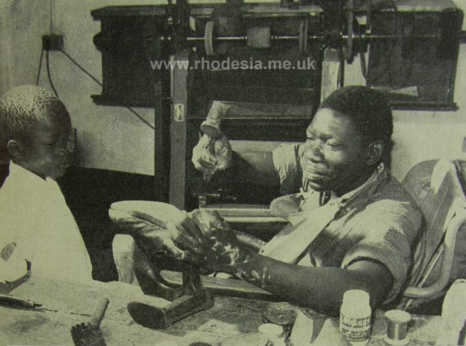 A paraplegia patient demonstrating shoe repairing in Bulawayo